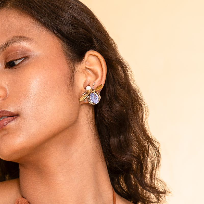 Detail of Model wearing Deepa Gurnani handmade the Firefly earrings in Lavender color