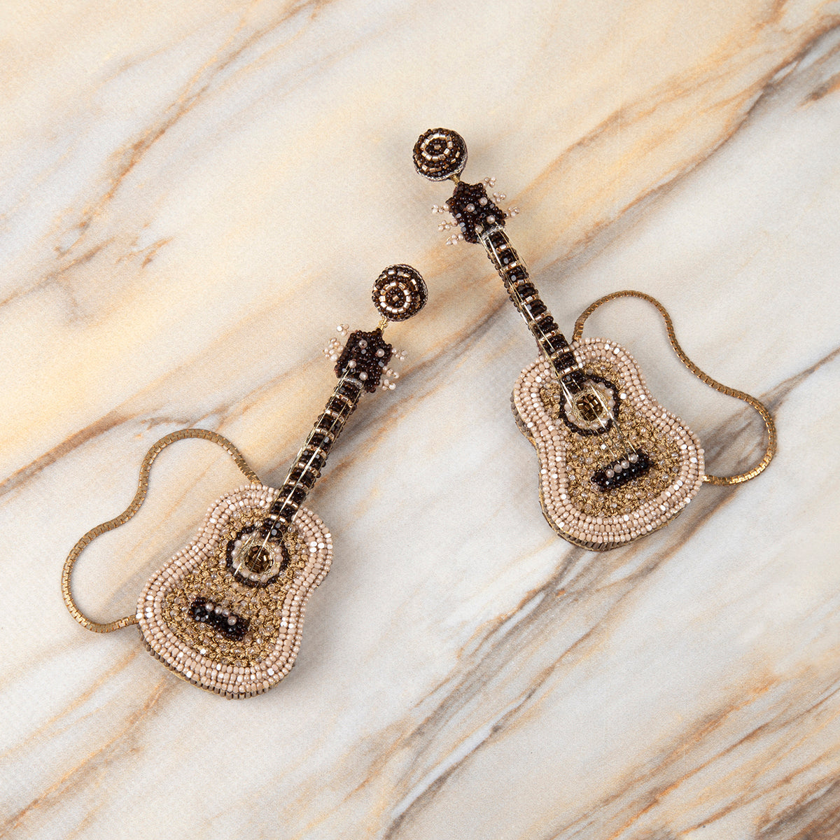 Deepa Gurnani Handmade Guitar Earrings on marble background