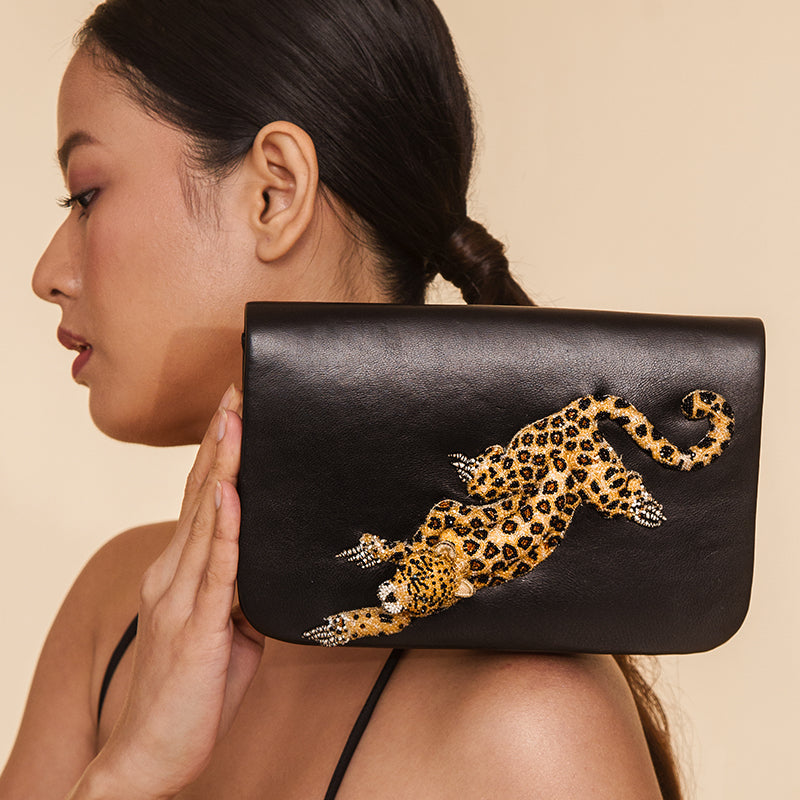 Detail of Model wearing Deepa Gurnani Handmade Leopard clutch in Black color